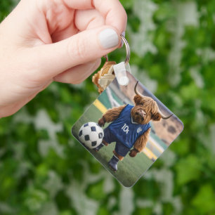 おもしろいサッカーの服を着た高地の牛 キーホルダー