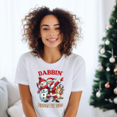 おもしろいサンタクロースが雪の中をダビングしている Tシャツ