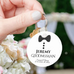 おもしろいブラックタイタキシードグロムスマン結婚式の引き出物 キーホルダー<br><div class="desc">この可愛いキーチェーンは、あなたのgroomsmenのためのギフトとして設計されている。白い背景に黒いボウタイとボタンを持つおもしろいデザインを備えている。彼の名読前の場所を持つ文字のグルームスマンは、彼のカップルの名前と日結婚付き。彼素晴らしに感謝していは結婚披露宴の一部として。</div>