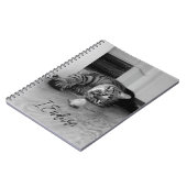 おもちゃマウスを見ながら横に寝そべった退屈なタビー猫 ノートブック (左側)