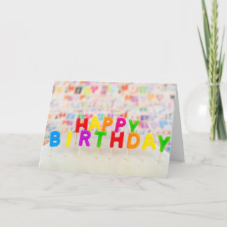 お誕生日おめでとう！ ローソクの色とったカードがケーキの上にある カード