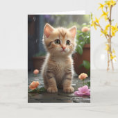 かわいいオレンジ色のタビー猫が花の間で座っている 空白のグリーティングカード カード (黄色い花)