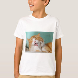 かわいいオレンジ色の猫のグルーミング Tシャツ