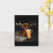 かわいいダックスフントがアイスコーヒーを飲む面白い犬のミーム カード (黄色い花)