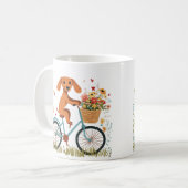 かわいいダックスフンドの犬が自転車に乗って春の花を満載したカゴを抱える コーヒーマグカップ (正面左)