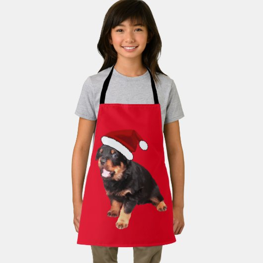 かわいいロットワイラー子犬マンガのサンタハットを着て エプロン (インサイチュ)
