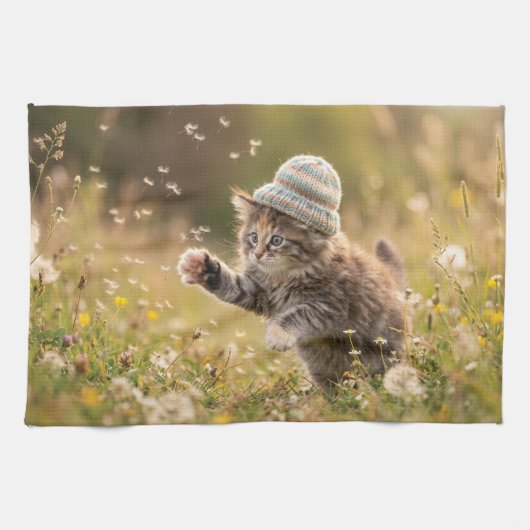 かわいい子猫が帽子をかぶってタンポポで遊ぶ キッチンタオル (横)