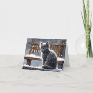 かわいい灰色の猫がベンチに座る冬の雪の白いグリーティングカード カード
