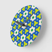 かわいい花が青と緑の幾何学的な花柄に飾られている ラウンド壁時計 (傾斜)