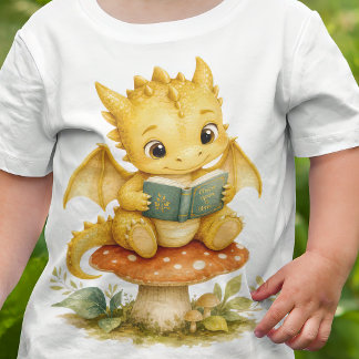 きのこで本を読むストーリーブックベビードラゴンの子供デザイン ベビーTシャツ