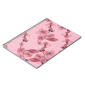 さくらんぼは白い背景にピンク色の花を咲かせる。 ノートブック (左側)