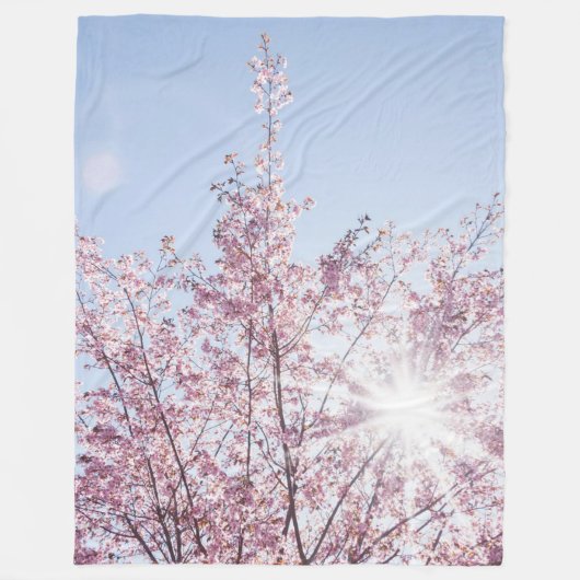 すさまじい木のピンク色の花を太陽が通過する フリースブランケット (正面)