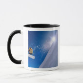 〜と飛んでいる共にスノーボードの上を空を通る人 マグカップ (左)