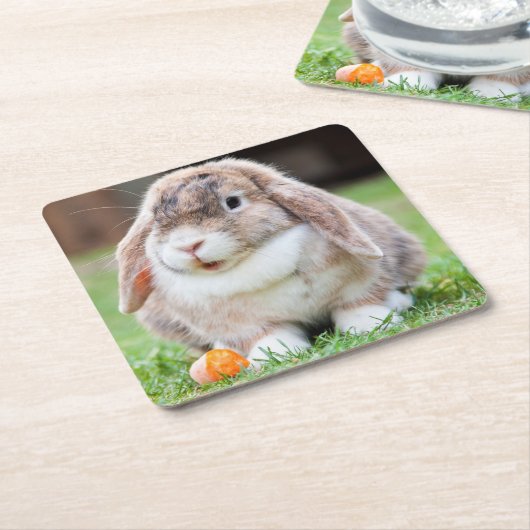 にんじん草の中の可愛い耳の垂れたウサギ スクエアペーパーコースター (アングル)