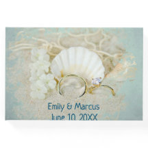 の結婚リングや輪と砂の貝殻
