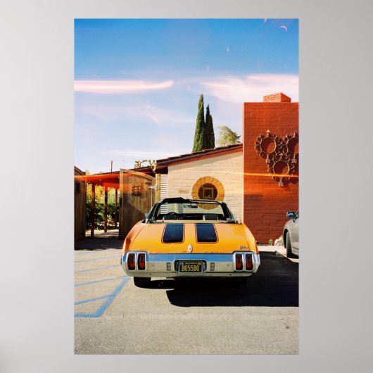 ～の茶色のコンクリート建物の横に止まっている青い車 ポスター (正面)