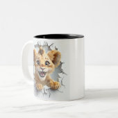 よくはしゃぐベビーライオンが防壁を貫いて現れる ツートーンマグカップ (正面左)