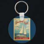 アウターバンクスSailboat Vintage Travel North Carolina キーホルダー<br><div class="desc">The Greeting From Outer Banksノースカロライナのヴィンテージ旅行デザイン航海のは、海の上を帆走する船と豪華で膨らんだ白い雲で満ちた青い空を特徴としている。</div>