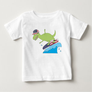 アメリカ国旗の恐竜サーフィン ベビーTシャツ