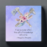 アラパホ先住民トマホークとアメリカの諺 フォトプラーク<br><div class="desc">アラパ感動的ホのインディアン部族/先住民のアメリカの諺は次のように言う：私たちもしは多くの場合、知識の贈り物は来多くの場合、あります。デザインはトマホークとハチェトが交差した水彩画で作られ、その中央には羽毛とピンクと黄色の花の花束がかわいらしある。背景は柔らかい紫色の青い水色のテクスチャ。</div>