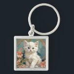 アルフォンスミュシャスタイルホワイトキャット キーホルダー<br><div class="desc">Alphonseミュシャのスタイルで白猫を登場！ピンクの花と青い毛布でポーズをとる青い目のふわふわの子猫。猫好きやアールヌーボーのコレクターへの素晴らしい贈り物！</div>