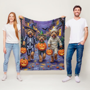 エアデイル・テリアの犬たちがハロウィンでお菓子を乞う様子 フリースブランケット
