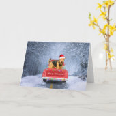 エアデール・テリアの犬が雪の上に座り、クリスマスを祝う カード (黄色い花)