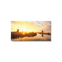 オランダの風車と川の上の日の出