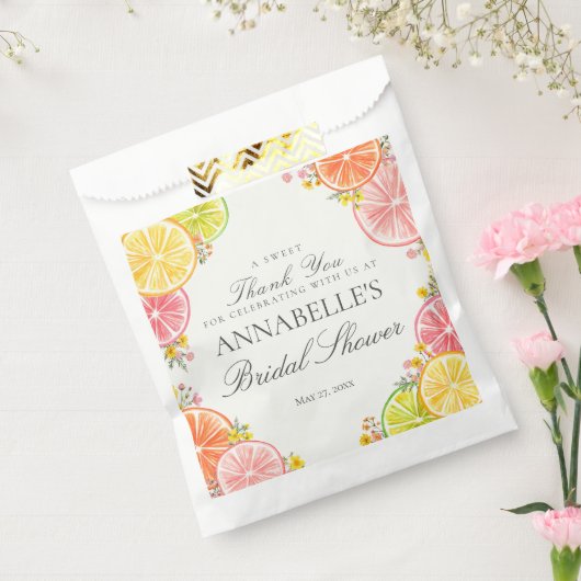オレンジとピンクの花を添えたさわやかな柑橘フルーツの ブライダルシャワーのデザート フェイバーバッグ (封をした状態)