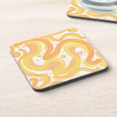 オレンジと黄色の渦巻き形にドットが付いている コースター (左側)