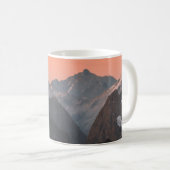 オレンジの空の下の茶色と白の山々 コーヒーマグカップ (正面右)