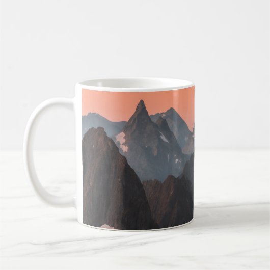 オレンジの空の下の茶色と白の山々 コーヒーマグカップ (左)