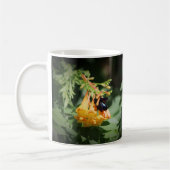オレンジ色のノウゼンカズラの花に止まる黒い蜂 コーヒーマグカップ (左)