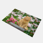 オレンジ色の猫とピンクの春の花 ドアマット (アングル)