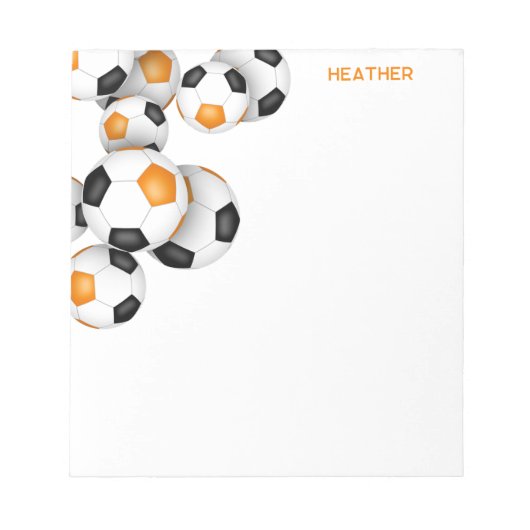 オレンジ色の黒いサッカーボールのアクセント名前をカスタムする ノートパッド (正面)
