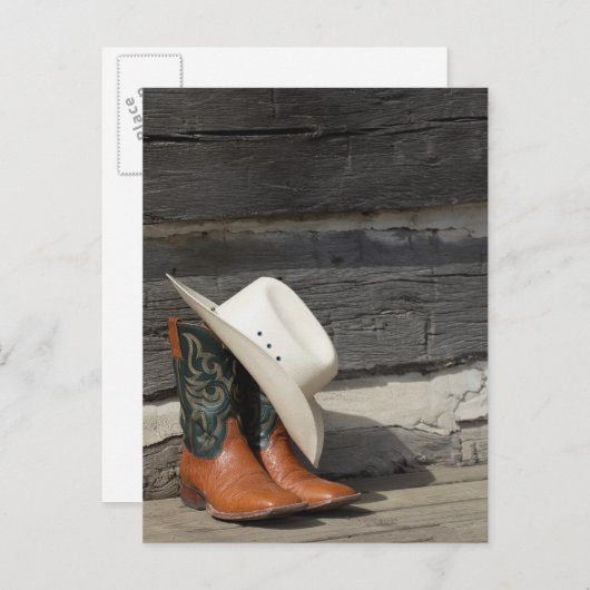 カウボーイの帽子を履いたカウボーイのブーツがログキャビンの外に置かれている ポストカード