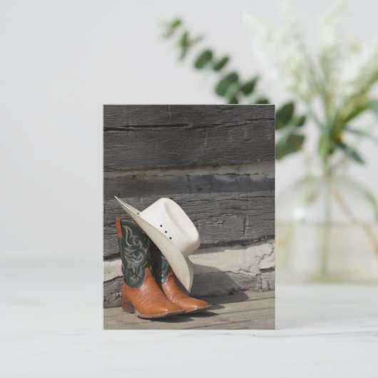 カウボーイの帽子を履いたカウボーイのブーツがログキャビンの外に置かれている ポストカード (スタンド正面)