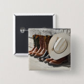 カウボーイブーツの列に並んだカウボーイハットが丸太の外にある 缶バッジ (正面&裏面)