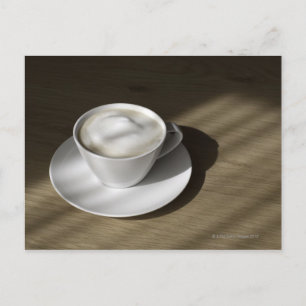 カシの上にカプチーノのコーヒーが1杯ある ポストカード