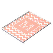 カスタムなモノグラムが付いている珊瑚のピンクおよび白いシェブロン ノートブック (左側)