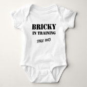カスタム年「Bricky in Training」 Bricklayerおもしろい ベビーボディスーツ (正面)