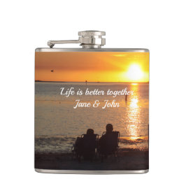 カップルはサンセットドリンクビーチで座るフラスコ フラスク