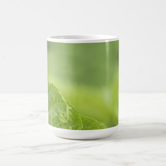 カールのシダの葉、緑の草木は、背景をぼやけました コーヒーマグカップ (中央)
