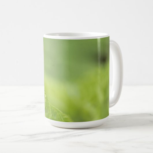 カールのシダの葉、緑の草木は、背景をぼやけました コーヒーマグカップ (正面右)
