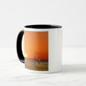 キリンの夫婦が夕暮れの中を歩く マグカップ (正面左)