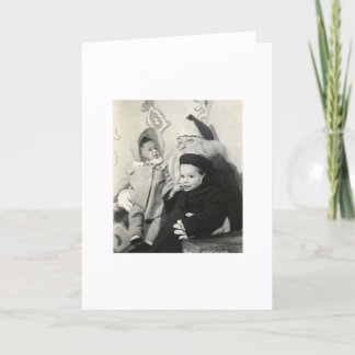 クリスマスのためのサンタのラップに坐っている子供 シーズンカード