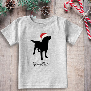 クリスマスのサンタの帽子を持つ黒い実験室犬 ベビーTシャツ