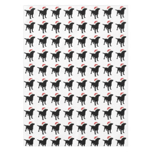 クリスマスのサンタクロースの帽子を身に着けている黒い実験室犬 テーブルクロス