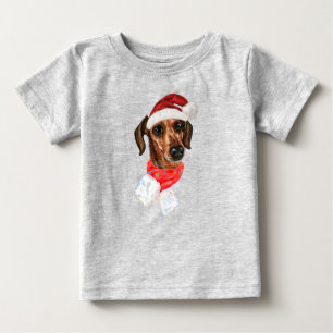 クリスマスのサンタ帽子をかぶったダックスフントのTシャツ ベビーTシャツ