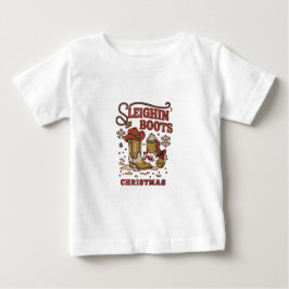 クリスマスのソリブーツ 楽しいウエスタンカウボーイ ベビーTシャツ